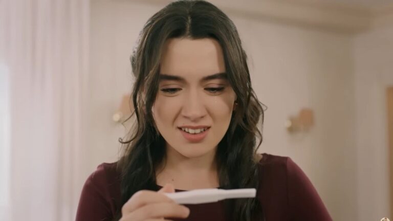 Zeynep ze wzruszeniem patrzy na test ciążowy.