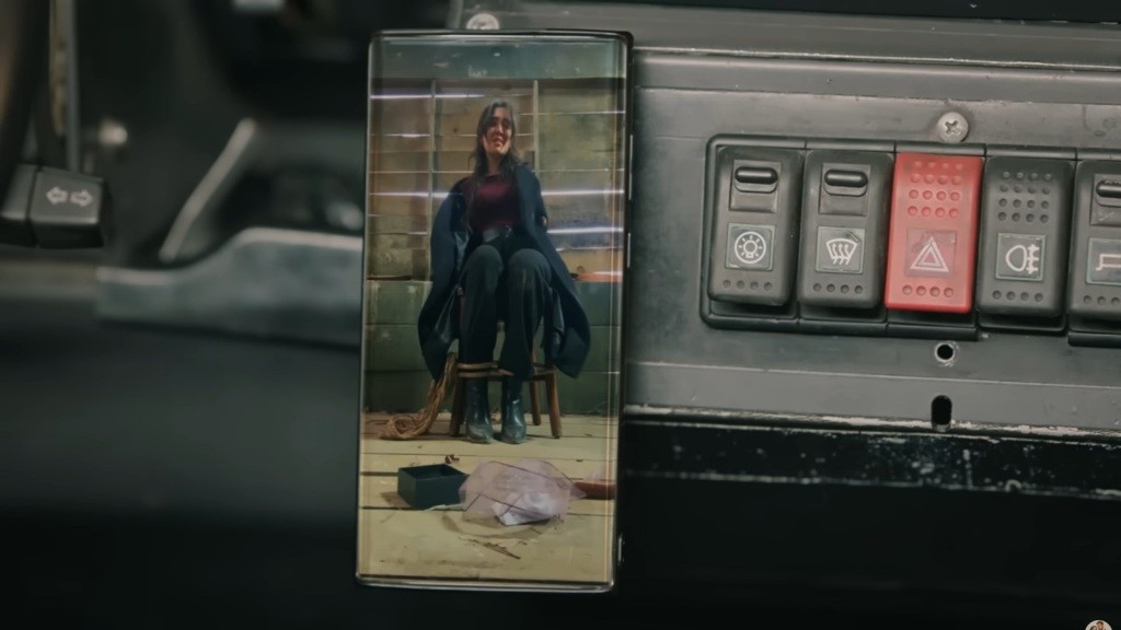 Na ekranie przyczepionego do deski rozdzielczej samochodu widać przywiązaną do krzesła Zeynep.