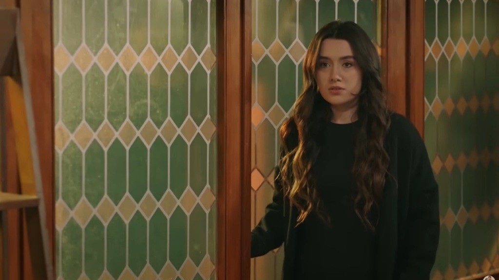 Zeynep stoi w pracowni przy drzwiach wejściowych.