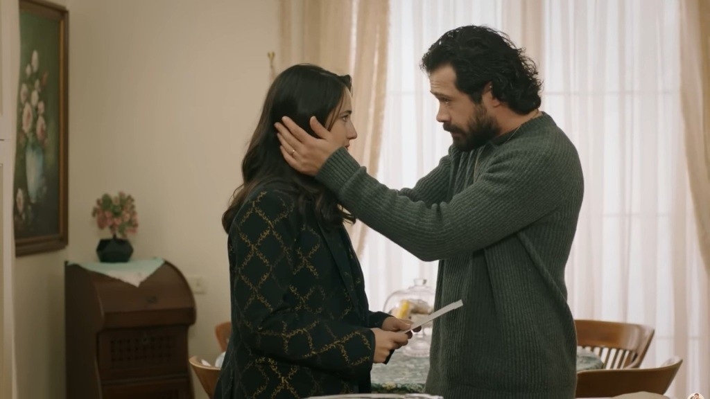 Tekin obejmuje dłońmi głowę Gulhan, która trzyma w rękach kopertę.