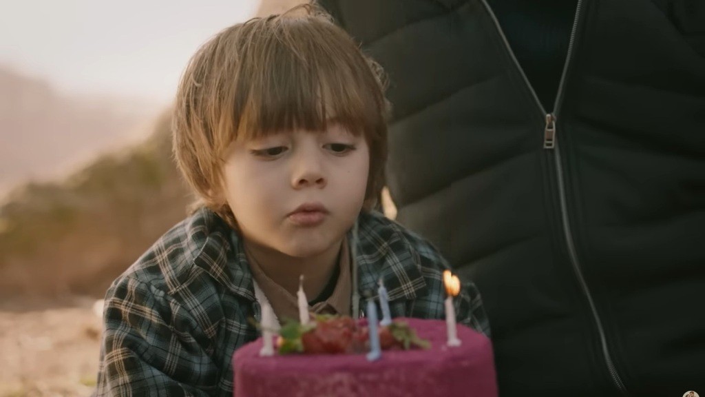 Pięcioletni syn Halila i Zeynep zdmuchuje świeczki z tortu urodzinowego.