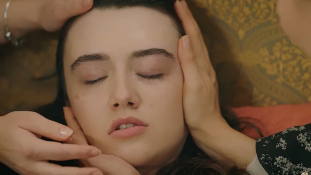 Zeynep jest nieprzytomna. Tulay obejmuje jej twarz.