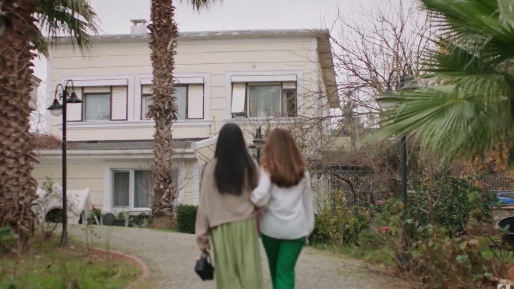 Beyza prowadzi Hancer w kamienistą ścieżką w stronę starego domu.