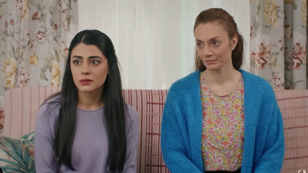 Hancer i Derya siedzą obok siebie na kanapie.