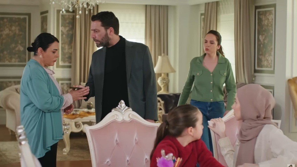 Nusret podaje Mukadder telefon, patrząc na nią gniewnie.