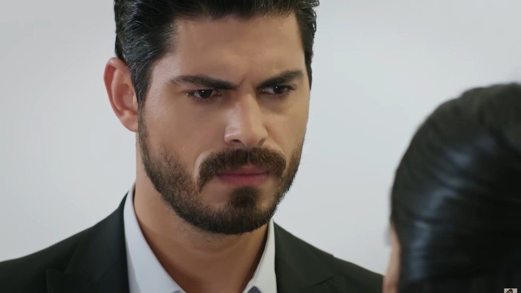 Cihan marszczy brwi, stojąc przed Hancer i patrząc jej w twarz.