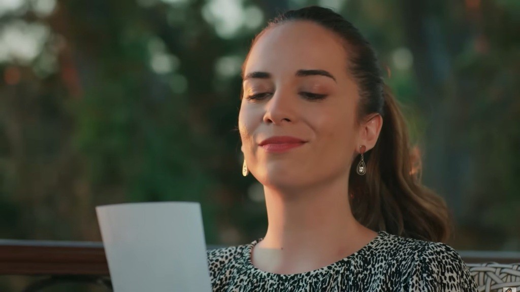 Beyza z uśmiechem na ustach patrzy na zdjęcie.