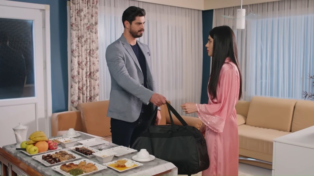 Cihan podaje Hancer dużą czarną torbę.