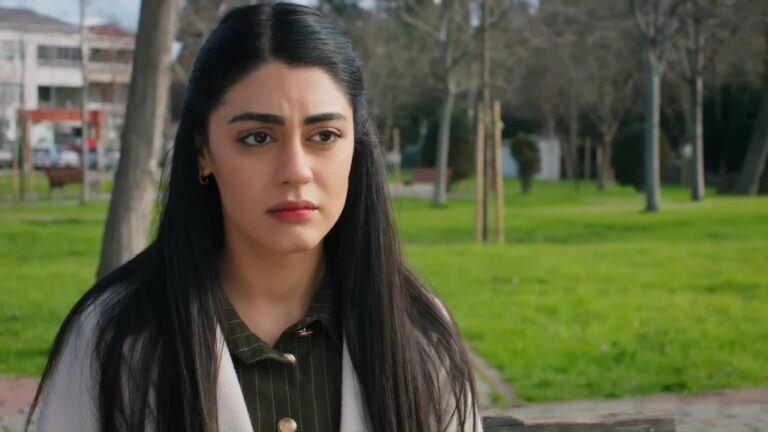 Hancer siedzi na ławce. Jej twarz wyraża zmartwienie.