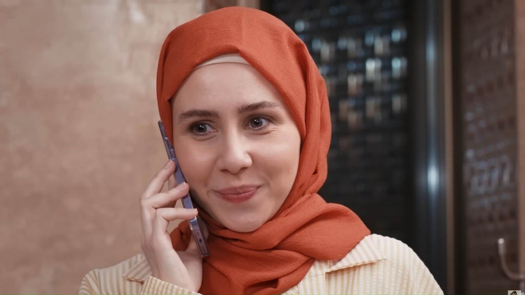 Sinem z uśmiechem na ustach rozmawia przez telefon.
