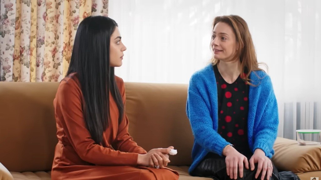 Hancer siedzi na kanapie obok Deryi.