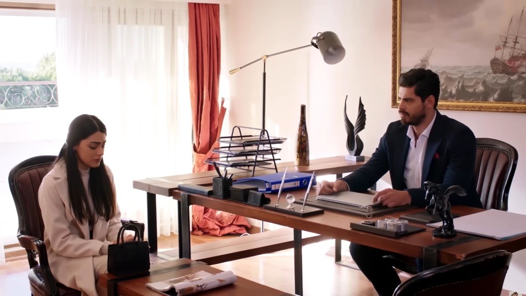 Hancer siedzi ze spuszczoną głową przy biurku Cihana.