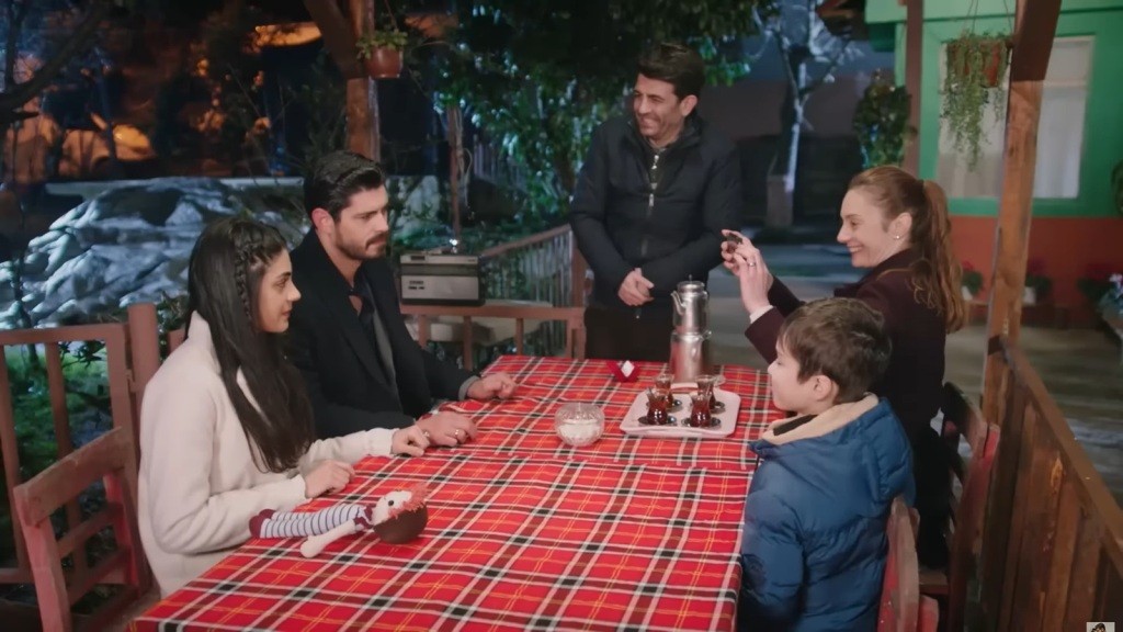 Hancer i Cihan siedzą przy stole. Naprzeciwko nich siedzą Derya i Emir. Cemil stoi tuż obok.