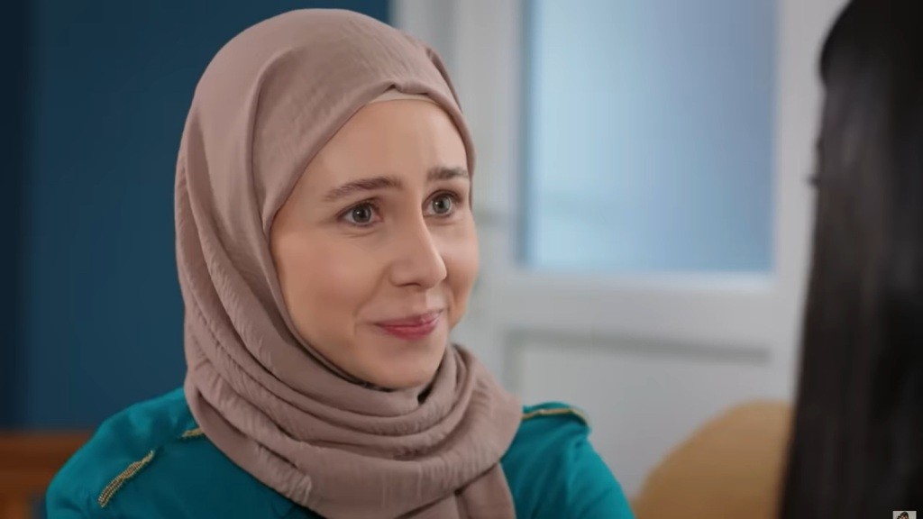 Zbliżenie na uśmiechającą się delikatnie Sinem.