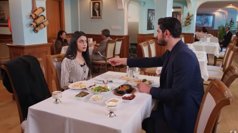 Hancer i Cihan siedzą przy stoliku w restauracji.