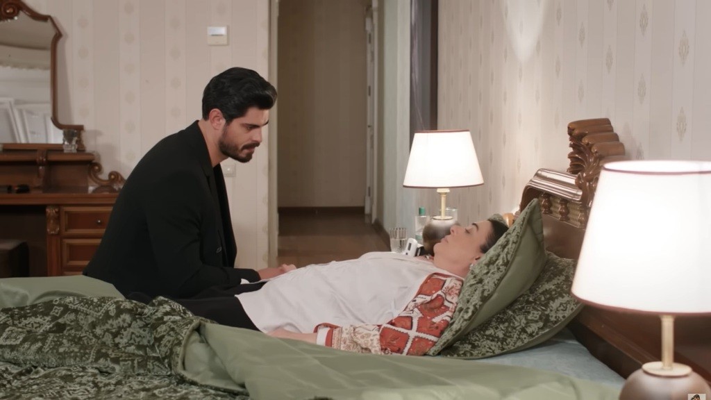 Cihan siedzi przy łóżku chorej matki.