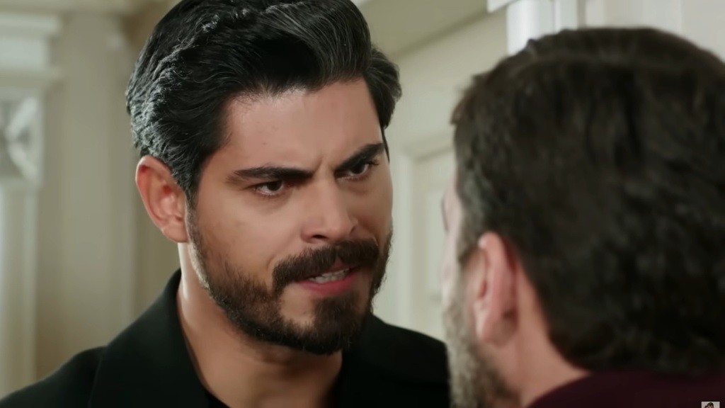 Cihan wbija gniewne spojrzenie w wujka.