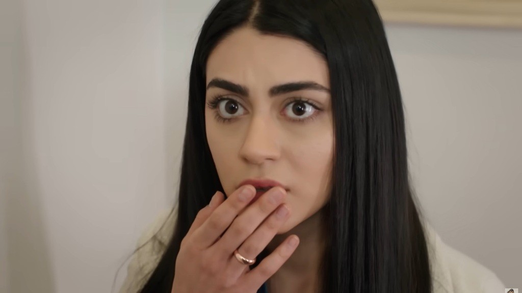 Hancer zasłania usta dłonią.