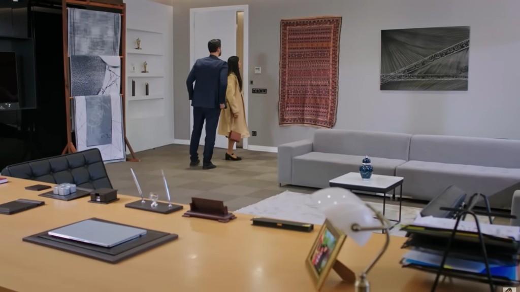 Cihan i Hancer oglądają wiszący na ścianie dywan.