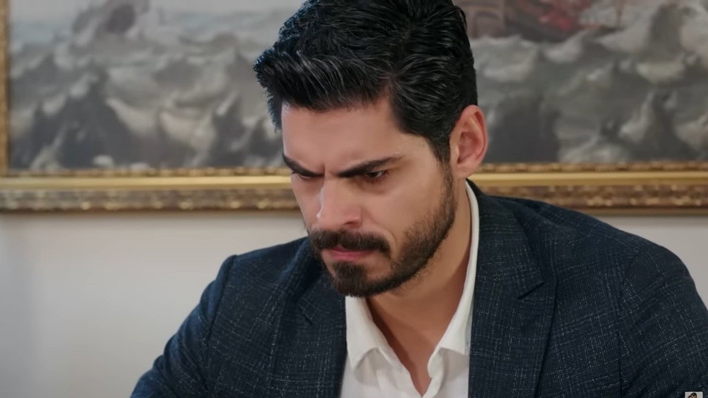 Cihan marszczy brwi, oglądając nagranie na laptopie.