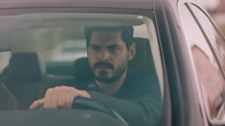 Cihan siedzi za kierownicą samochodu.