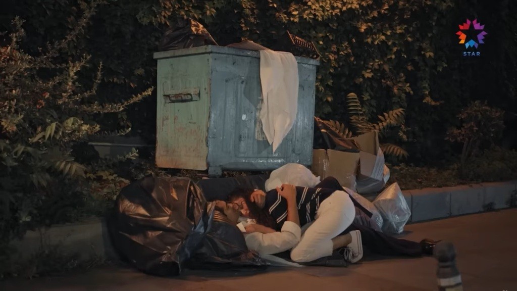 Diyar kładzie się obok Ferita na workach.