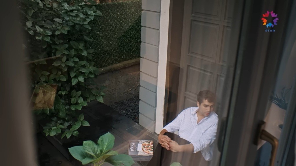 Ferit siedzi pod drzwiami domu Diyar.