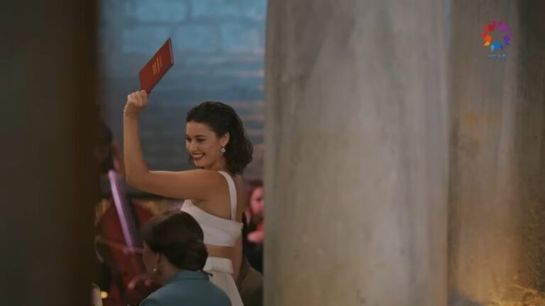 Seyran unosi rękę, w której trzyma akt małżeństwa.