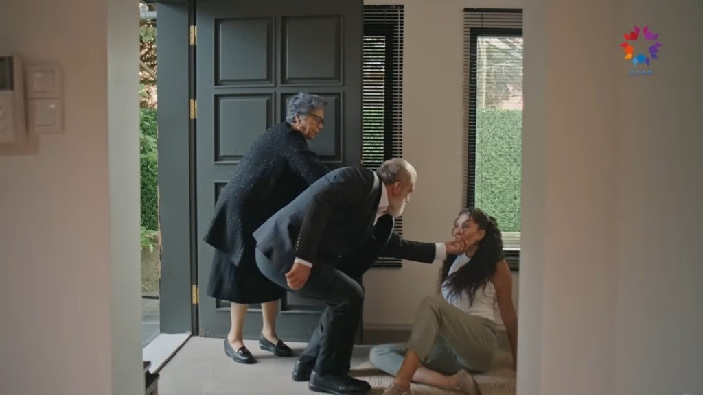 Diyar upada w przedpokoju. Dziadek pochyla się i chwyta ją za brodę.