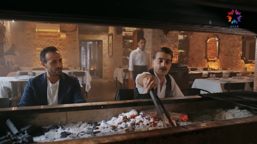 Abidin i Kazim siedzą przy grillu.