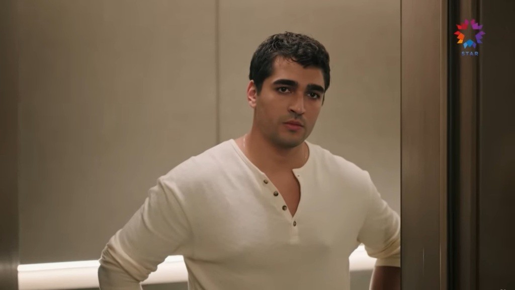 Ferit staje przed drzwiami pokoju hotelowego.