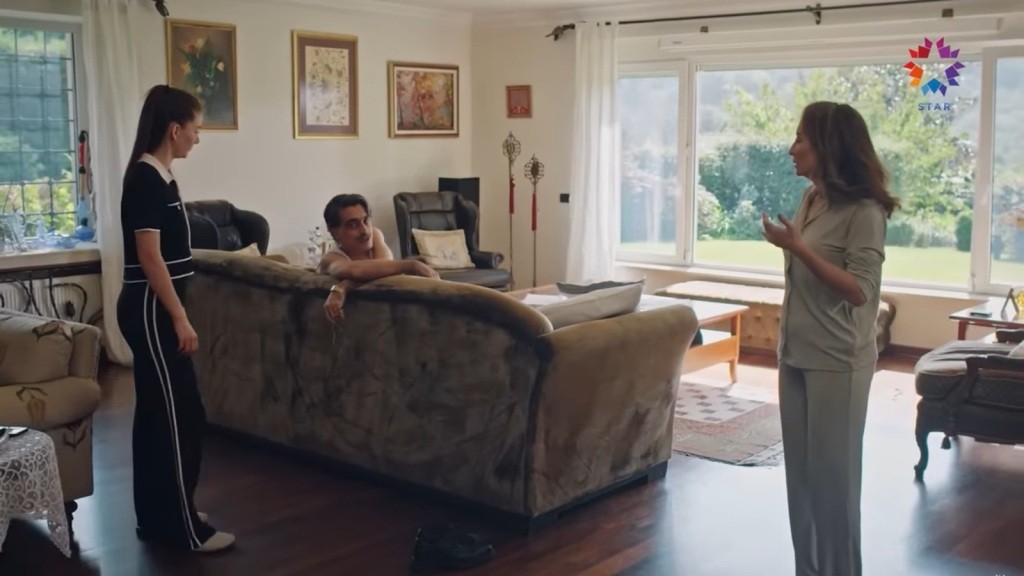 Kazim wygląda zza oparcia kanapy. Obok stoją Esme i Suna.