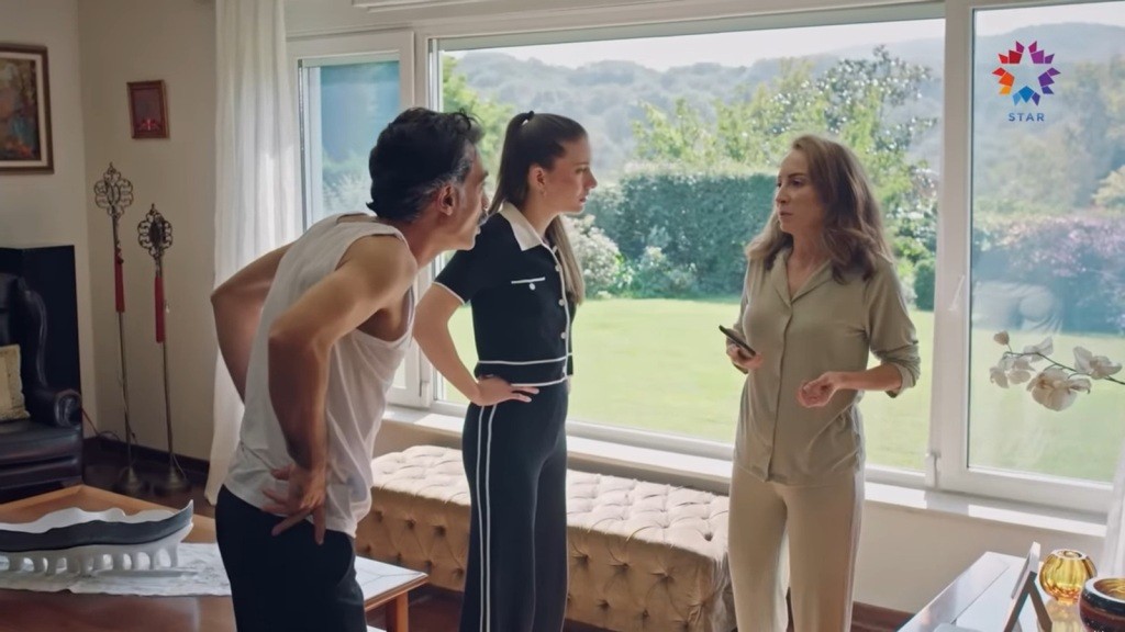 Esme trzyma telefon w ręku, na moment przerywając rozmowę. Kazim i Suna wpatrują się w nią intensywnie.