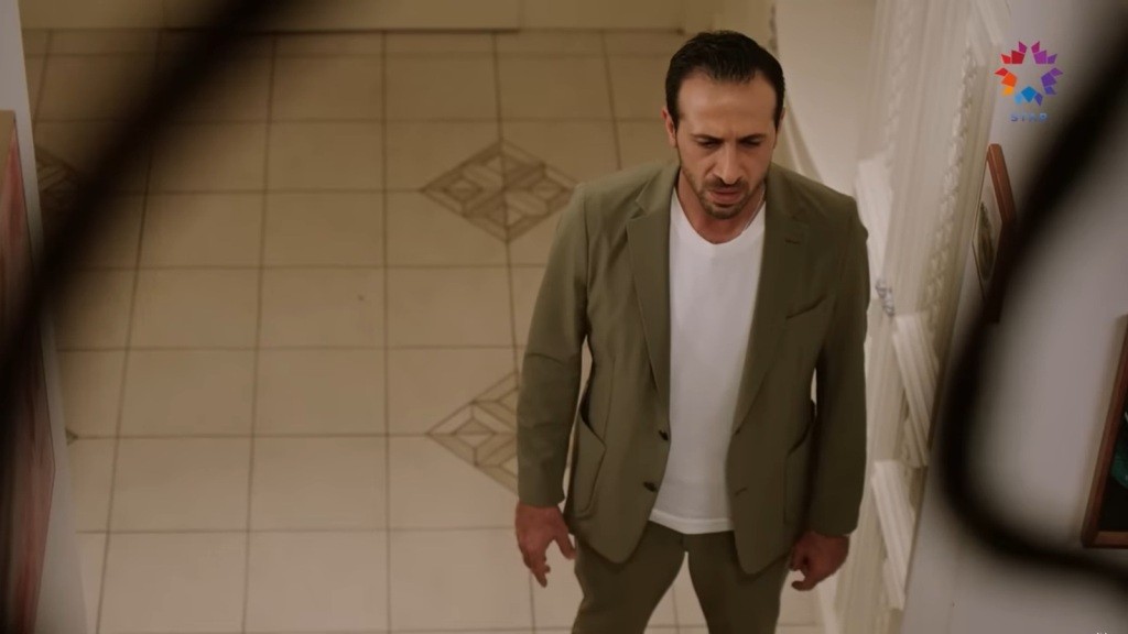 Abidin stoi w przedpokoju.