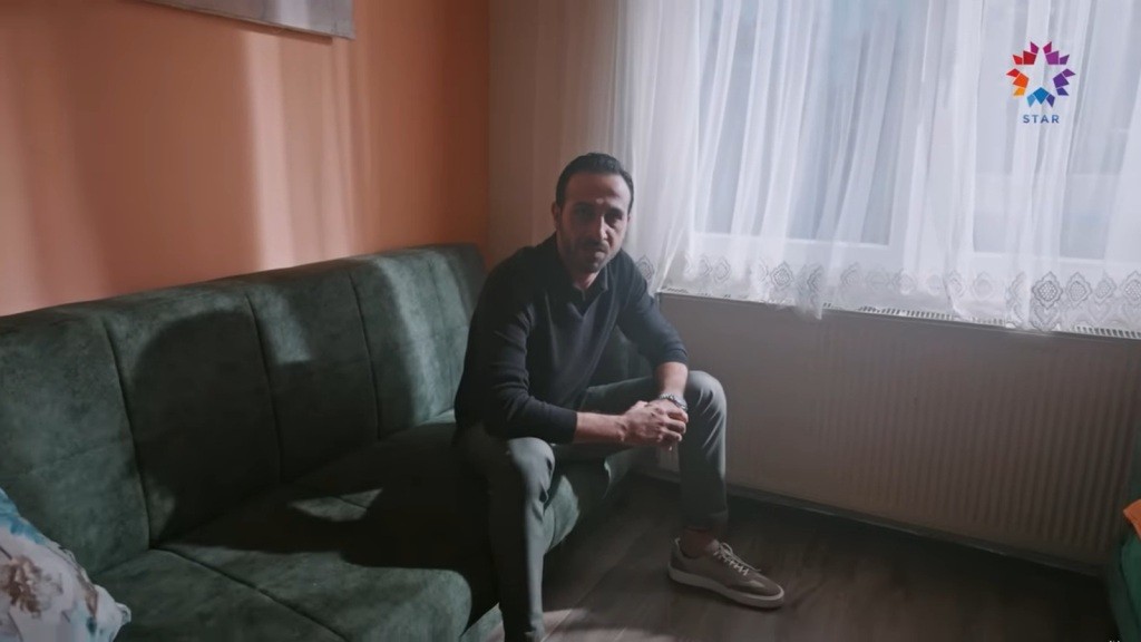 Zbliżenie na siedzącego na wersalce Abidina.