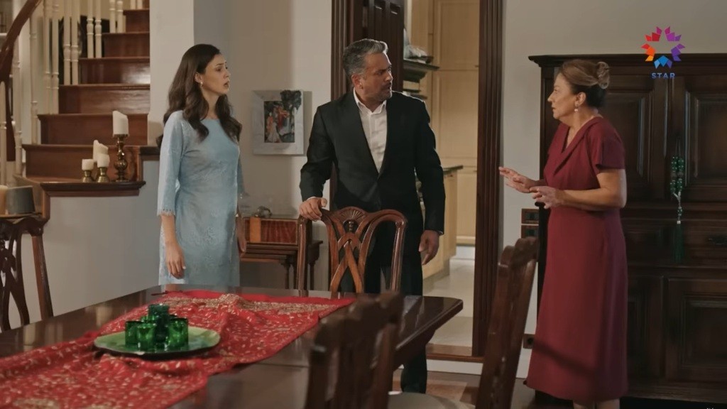 Betul, Orhan i Nurten stoją obok stołu w jadalni.