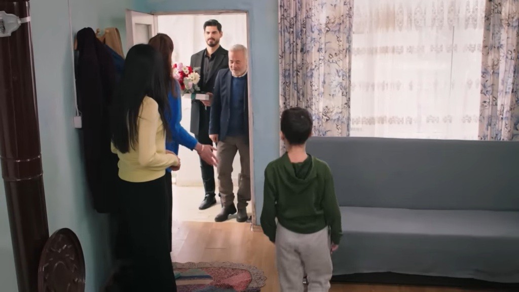 Cihan i Ertugrul przychodzą do domu Cemila. Cihan trzyma w rękach bukiet kwiatów.