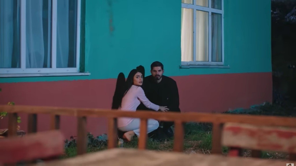 Hancer i Cihan kucają pod ścianą domu.