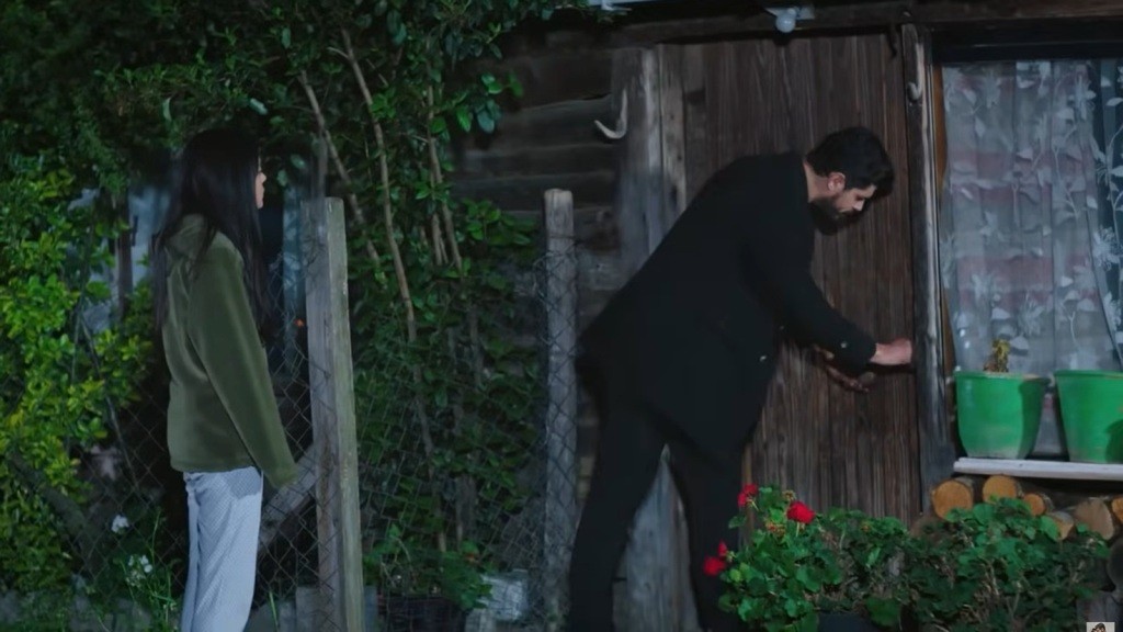 Cihan otwiera drzwi chaty. Za jego plecami stoi Hancer.