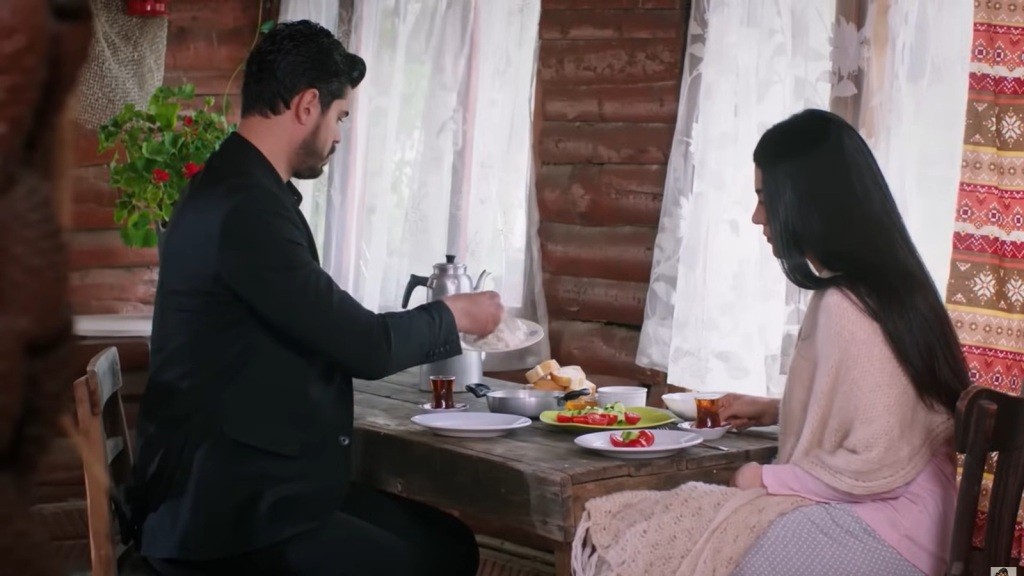 Cihan nakłada jedzenie na talerz.