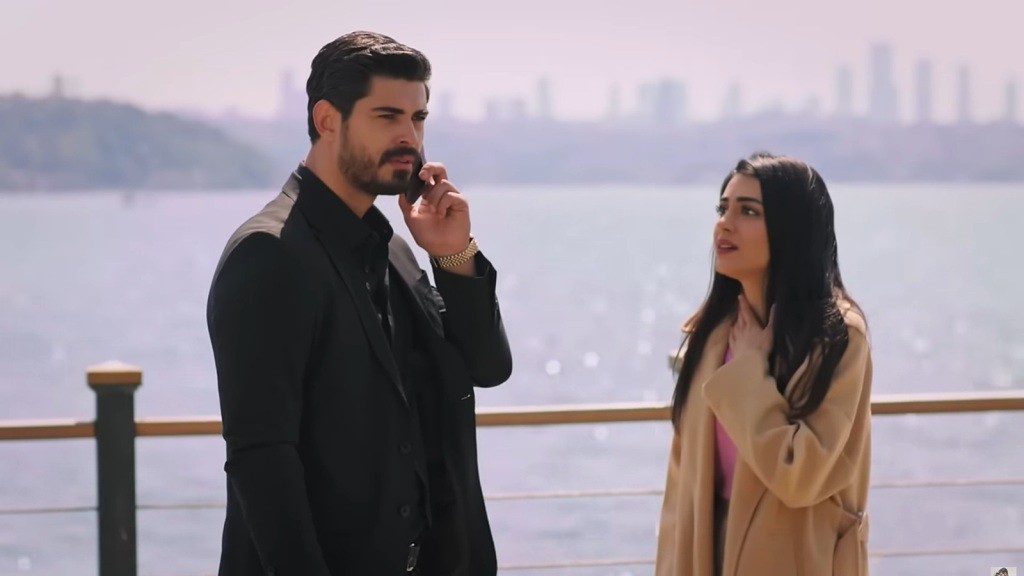 Cihan rozmawia przez telefon. Hancer stoi obok i patrzy na niego z niepokojem, trzymając się za szyję.