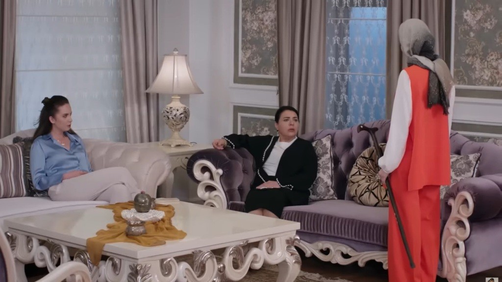 Sinem stoi przed Mukadder, trzymając w ręku jej laskę.