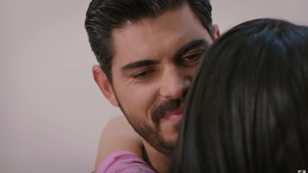 Cihan uśmiecha się, gdy Hancer zawiesza mu się na szyi.