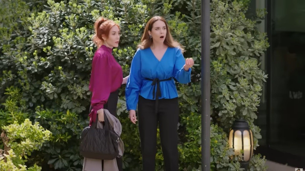 Beyza otwiera szeroko usta, zszokowana. Obok niej stoi Yonca.