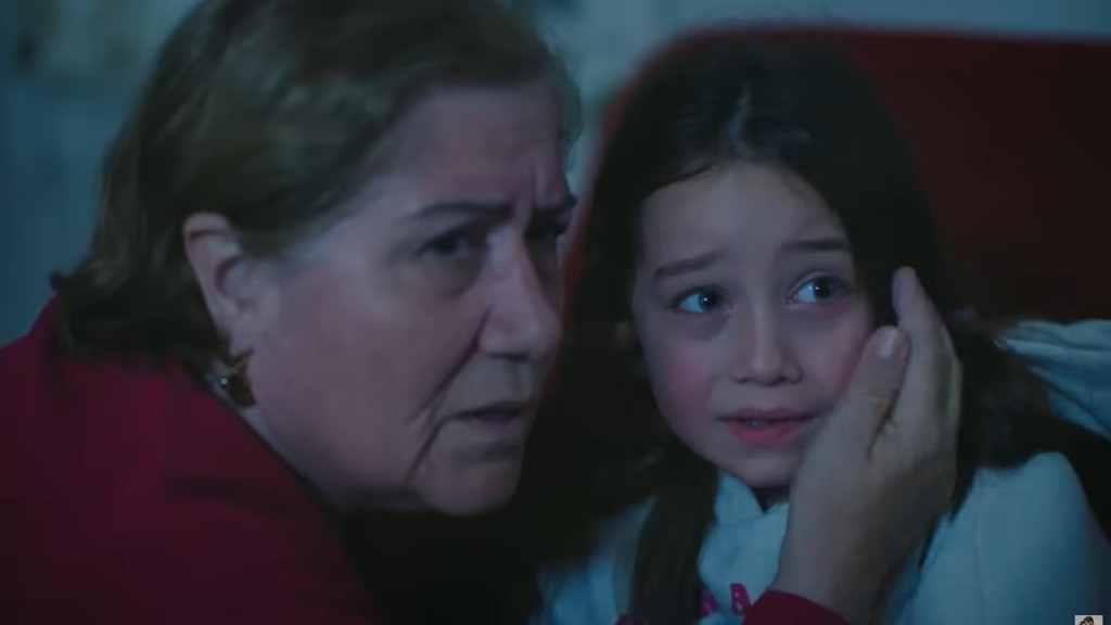 Starsza kobieta i Mine patrzą w jednym kierunku. Obie są poruszone i przestraszone.