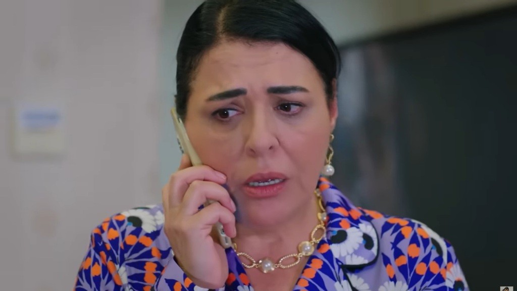 Mukadder rozmawia przez telefon. Na jej twarzy maluje się głęboki niepokój.