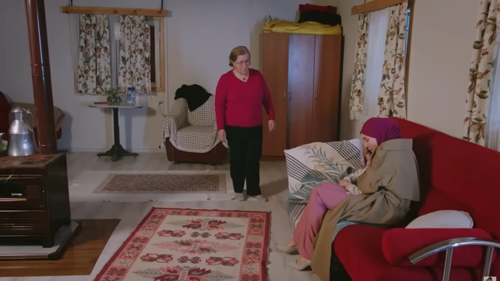 Sinem przytula córkę, siedząc przy niej na kanapie.