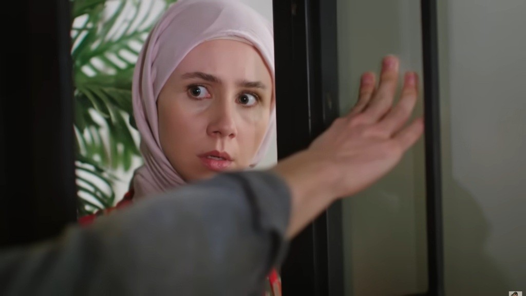 Męska ręka blokuje drzwi, za którymi stoi Sinem.