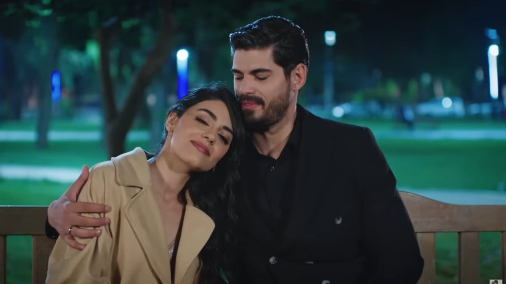 Cihan i Hancer spędzają romantyczny wieczór w parku, siedząc blisko siebie. Ich czułe gesty i uśmiechy tworzą magiczną atmosferę miłości pod nocnym niebem. On obejmuje ją, a ona trzyma głowę na jego ramieniu.