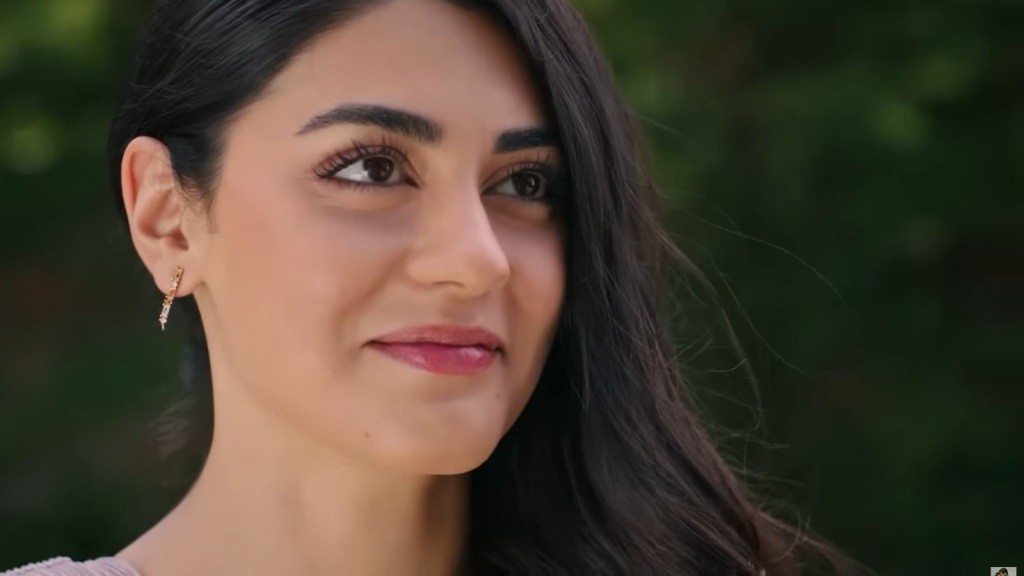 Zbliżenie na twarz uśmiechniętej kobiety, której promienna uroda i wyraz radości przyciągają uwagę. Jej delikatne rysy i błyszczące oczy zdradzają pewność siebie i pozytywne nastawienie.